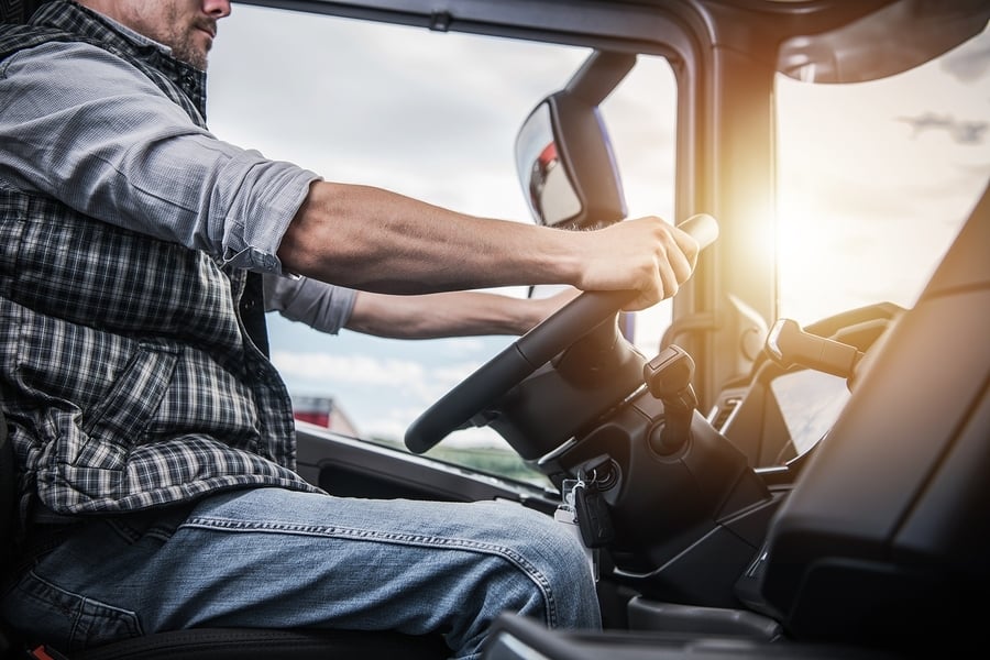 Truck Driver behind the Wheel. Semi Truck Driving and Transporta